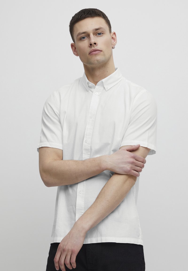 Weißes Kurzarmhemd aus leichtem Stoff mit Button-Down-Kragen, gerader Säume und minimalistischem Design.