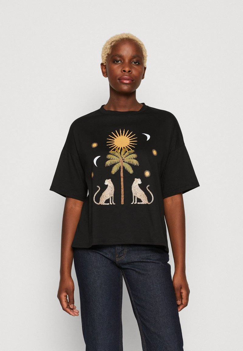 T-shirt nera in cotone con un design grafico di due leopardi e una palma, arricchito da motivi di sole e luna in colori oro e crema.