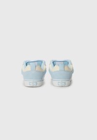 Blue suede low-top sneakers with cream accents and a white rubber sole. Features a logo on the heel and fabric loops for easy wear.