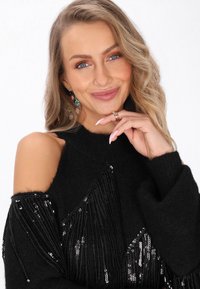 Czarny sweter z dekoltem na ramionach, ozdobiony cekinową frędzlą. Miękka tekstura z wysokim kołnierzem i długimi rękawami.