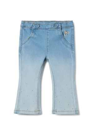 Pantalones de mezclilla azul claro con efecto de desvanecimiento, cierre de dos botones, bolsillos frontales y pequeños tachones dorados que adornan la parte inferior de las piernas.