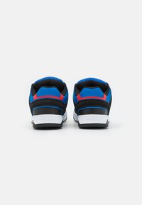 Sneaker nere e blu con accenti rossi, tomaia in tessuto e sintetico, suola bianca, collare imbottito e dettagli con logo sul tallone.