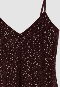 Burgundia värvi sädelev kleit, millel on V-kaelus, õhukesed rihmad ja tekstuuriga pind, millel on kogu ulatuses jaotatud läikivad ümmargused sequins.