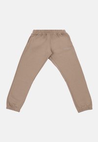 Pantalons de jogging beiges en mélange de coton doux, avec une taille élastique, des poignets resserrés et un logo brodé subtil sur le côté.