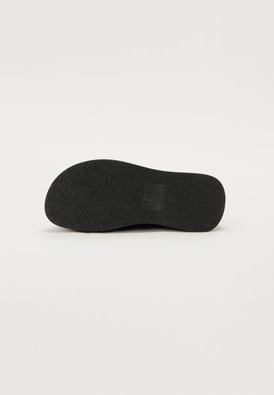 Talpa de pantof din cauciuc negru, cu o suprafață texturată având un model în zigzag și un ștanțat cu logo. Vârf rotunjit și margini netede.