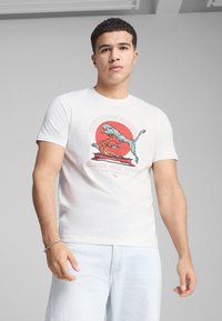 Camiseta blanca de algodón con un diseño gráfico colorido de un árbol y una ola, acompañado del texto "Fomentando Mentes" y "Da forma a tu futuro."