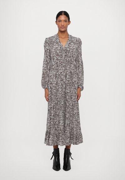 Vestido largo de flores marrón con escote en V, mangas abullonadas y dobladillo con volantes. Combinado con botas negras de tobillo, de punta afilada.