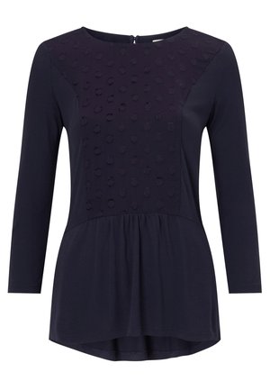 Donkerblauw langemouwtop met een textuur met stippenpatroon op het bovenpaneel, lichtgewicht stof, ronde halslijn en een peplumrand.