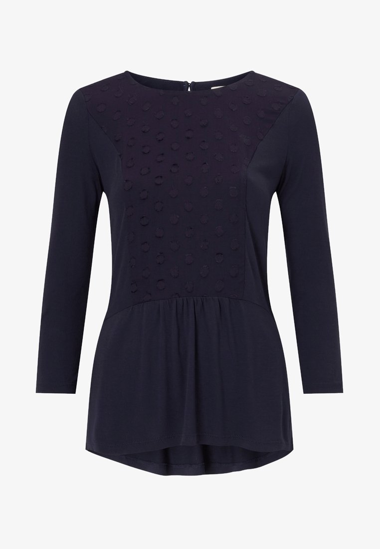 Granatowa bluzka z długim rękawem, z teksturowanym, kropkowanym wzorem na górnym panelu, lekkiego materiału, okrągłym dekoltem i falbaną u dołu.