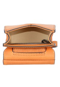 Orangene Leder-Geldbörse mit glatter Textur, offenem Design, braunen Nähten und einem kleinen Riemen zum Verschließen. Das Innere ist beige.