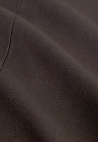 Mörkbrun tyg med en jämn textur, som visar en subtil lyster och fin väv, med en vikt och draperad utseende.