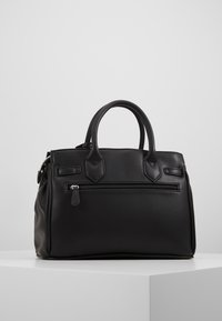 Black leather handbag with dual handles, structured design, front zipper pocket, and textured finish. Features minimal hardware accents.