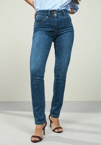 Högmidjade blå denimjeans med slim fit, som har två framfickor och två dekorativa knappar vid midjan.