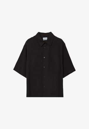 Chemise noire à manches courtes avec un col pointu, présentée à plat sur un fond blanc.
