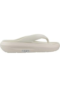 Chanclas de color beige claro con un diseño simple. Fabricadas en goma, cuentan con una correa texturizada y una suela acolchada. Etiqueta de talla estampada en la parte inferior.