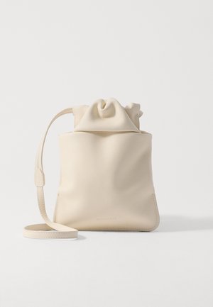 Paprastas, švelnus, šviesiai pieniškas odinis maišelis su raišteliu. Savybės: minkštas, sukauptas viršus ir plonas peties diržas. Minimalistinis dizainas be matomų detalių.