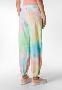 Tie-dye joggers med pastelfarver i pink, blå, grøn og gul, med elastisk talje og elastiske manchetter ved anklerne.