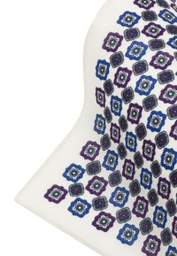 Biała tkanina z powtarzającym się geometrycznym wzorem przedstawiającym niebieskie i fioletowe kształty kwiatów z ciemnymi konturami oraz skomplikowanymi wewnętrznymi detalami.