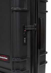 Black hard-shell suitcase with textured surface, combination lock, and reinforced corners. Features a sturdy handle and branded logo.