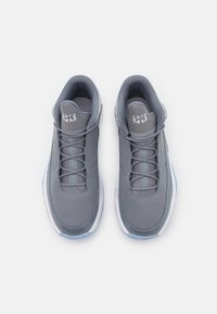 Par de zapatillas deportivas grises con detalles de malla y ante, suelas blancas y "23" bordado en la lengua, vistas desde arriba.