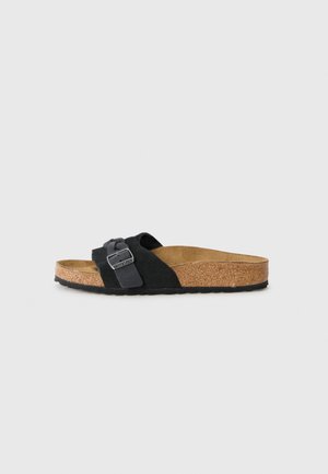 Sandale à glissière en suède noir avec un pied en liège et une semelle extérieure en caoutchouc texturé, dotée d'une large sangle réglable avec une boucle en métal.