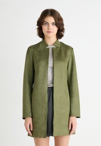 Veste verte olive à manches longues en matériau doux semblable à du daim, dotée d'un col mandarin et d'une coupe droite sans fermetures visibles.