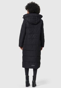 Abrigo acolchado negro hasta la rodilla con capucha, con costuras horizontales, un parche de logo en el dobladillo y una tela lisa y texturizada.