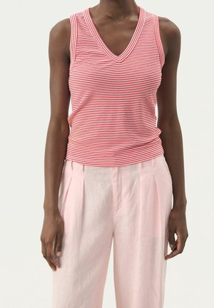 Rood-wit gestreepte mouwloze top met een V-hals ontwerp, gemaakt van geribbelde stof. Gecombineerd met lichtroze geplooide broek.