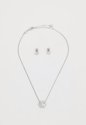 Collana d'argento con un pendente floreale decorato con accenti di cristallo chiaro; accompagnata da orecchini a bottone coordinati, anch'essi in argento con pietre trasparenti.