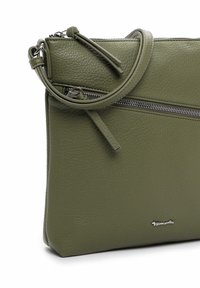 Crossbodytas van olijfgroen gestructureerd leer met voorvak met rits, verstelbare riem en klein zilverkleurig merkembleem.