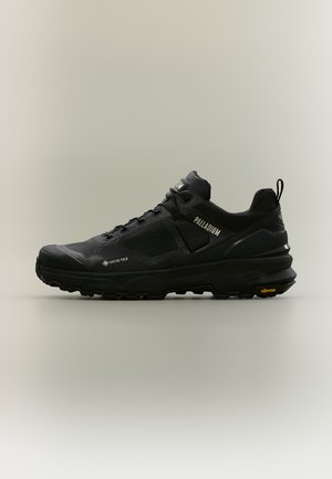 Μαύρο αθλητικό παπούτσι με υλικό Gore-Tex, παχιά σόλα Vibram και λογότυπο Palladium, εμφανίζεται από τη δεξιά πλευρά σε ουδέτερο φόντο.