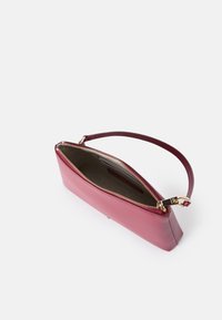 Rosa Leder-Clutch mit einem goldenen Reißverschluss, hat eine schlanke, rechteckige Form und einen kurzen Griff. Das Innere zeigt ein weiches Futter.