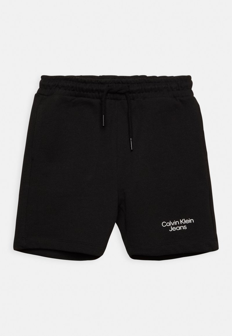 Pantaloni corti neri in cotone con vita elasticizzata e cordoncino, caratterizzati da un logo bianco "Calvin Klein Jeans" sulla gamba sinistra.