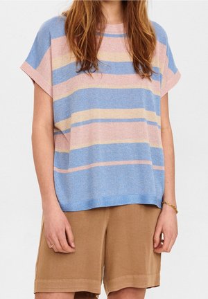 Frau trägt ein lockeres, kurzärmeliges Strickoberteil mit pastellrosa, blauen und beigen horizontalen Streifen sowie braune Shorts bis zum Knie.