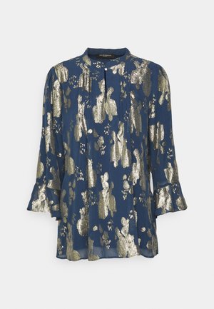 Tengerész kék blúz kerek nyakkivágással, fényes arany absztrakt mintával, hosszú ujjakkal, fodros részletekkel, és elülső gombos záródással.