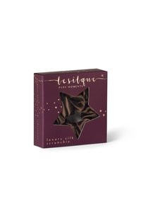 Luksusowa jedwabna gumka do włosów prezentowana w wycięciu w kształcie gwiazdy, zapakowana w ciemnofioletowe pudełko z złotym napisem i gwiazdkowymi akcentami.