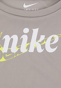 Grey Nike Dri-FIT T-shirt featuring a large white "Nike" logo with a yellow accent swoosh, made from smooth, breathable material.