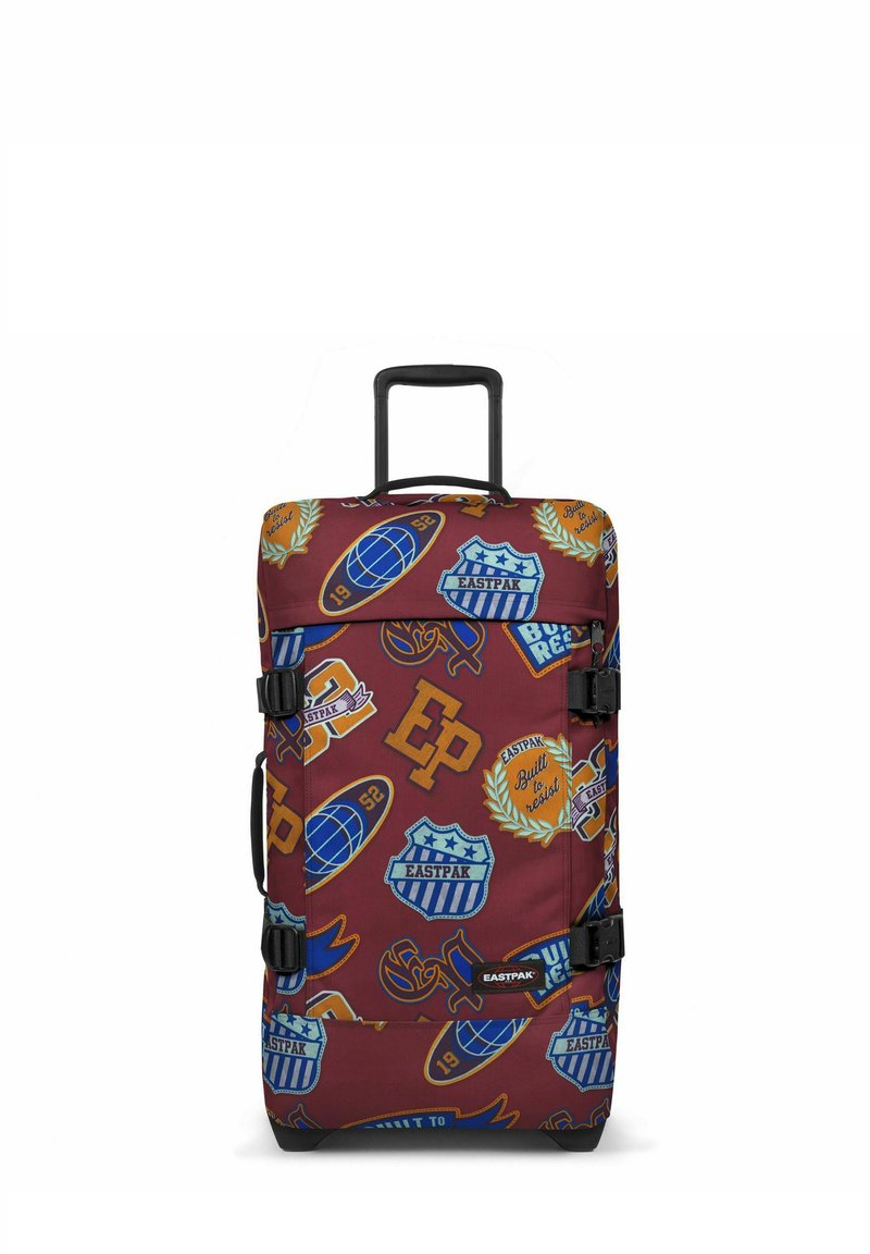 Borsa da viaggio in tessuto rosso con diversi toppe a tema sportivo di vari colori, dotata di manici e fibbie nere, manico estensibile e base rinforzata.