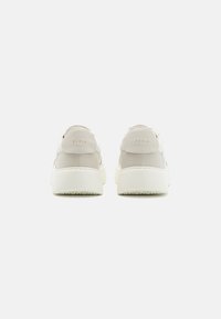 Világosszürke és fehér sneaker, sima felülettel, párnázott bokarésszel és diszkrét "FURLA" felirattal a saroknál.