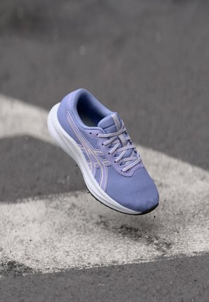 Gaiši violetas sporta apavi ar sietu augšdaļu, baltu zoli un violetiem akcentiem. Iekļauj šņorēšanu un vieglu faktūru virsmā.