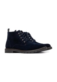 Botines de ante azul marino con puntera redonda, diseño de cordones de seis ojales, costuras rojas en contraste y suela de goma duradera.