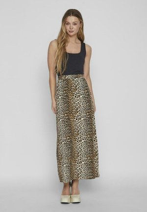 Maxiröcke mit Leopardenmuster und hoher Taille, aus glattem Stoff gefertigt. Kombiniert mit einem schwarzen Tanktop und hellen Schuhen.