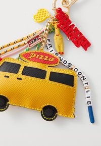 Geel leren sleutelhanger in de vorm van een pizzabezorgbus, met rode letters, kleurrijke kralen en verschillende charme-accenten, waaronder een cassette.