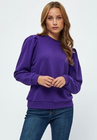 Lila sweatshirt med långa ärmar, puffade axlar, rund halsringning, ribbade muddar och nederkant, mjukt material och avslappnad passform.