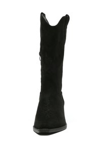 Bota cowboy de ante negro con punta afilada, parte superior texturizada y costuras decorativas cerca de la punta. Cuenta con un cierre de cremallera en el costado.