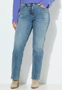 Jeans de mezclilla azul claro con un diseño de pierna recta, estilo de cuatro bolsillos estándar y una cintura alta. Desgaste mínimo.