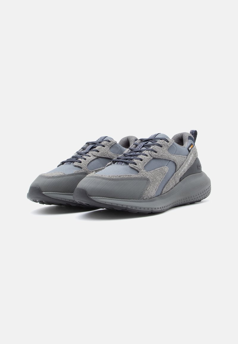 Graue Sneakers aus einer Mischung verschiedener Texturen, hauptsächlich aus Strick und Wildleder, mit einer dicken Gummisohle und Schnürdesign.