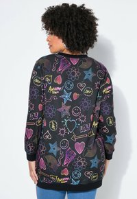 Felpa nera con doodles e motivi colorati, tra cui stelle, cuori e testi. Maniche lunghe con polsini a costine. Tessuto morbido.