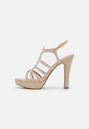 Sandale à talons hauts à lanières en matériau beige texturé, ornée de rhinestones clairs, avec une plateforme et une sangle à boucle à la cheville.