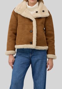 Bruine suède jas met beige bontkraag en voering, voorzien van knoopsluitingen en twee zijzakken; met een gestructureerde afwerking.
